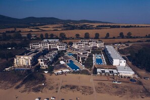 An aerial view of a resort with multiple buildings, a swimming pool, and a beach area. - Apolonia Resort (Sozopol)