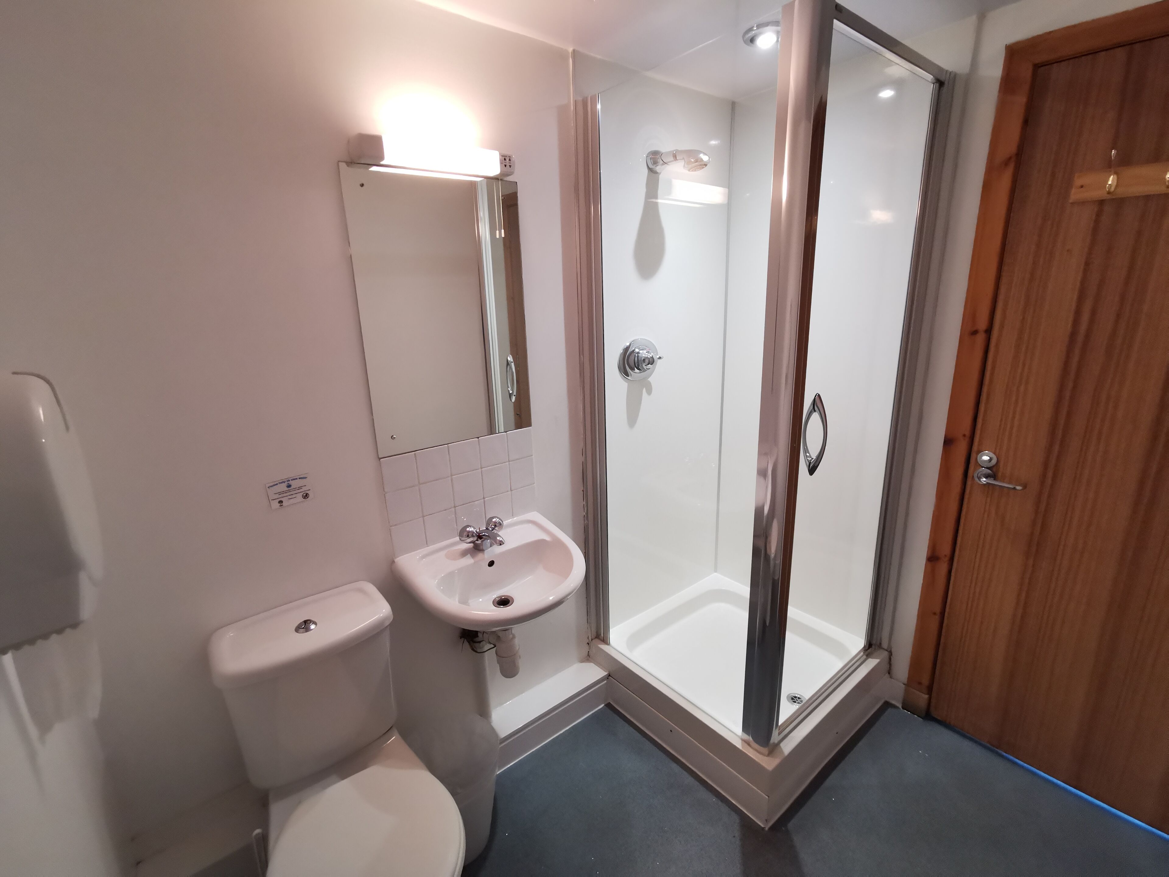 A bathroom with a toilet, sink, and shower.
