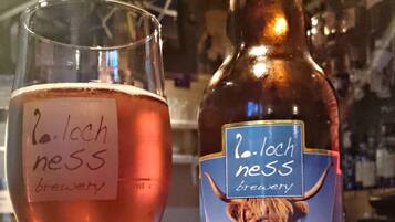 Una botella de cerveza Awesome Ness de la cervecería Loch Ness y un vaso con la misma etiqueta.