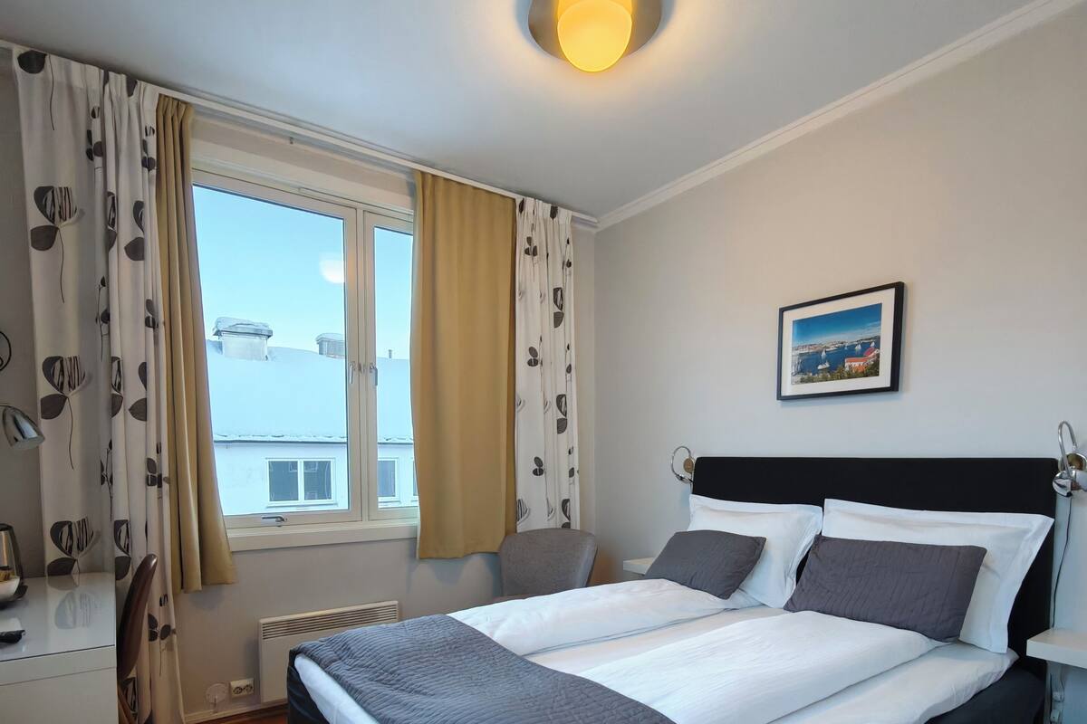 Escritorio, cortinas blackout y tabla de planchar con plancha