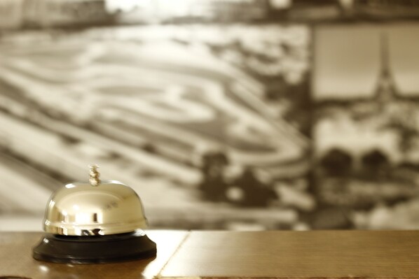 Ein Hotel-Empfangsbereich mit einem Holztresen und einer Rezeption.