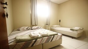 A bedroom with a large bed, a smaller bed, and a nightstand. - Hotel Interlagos Xua (São Paulo)