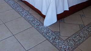 Habitación de hotel con dos camas, un ventilador de techo y suelo estampado.