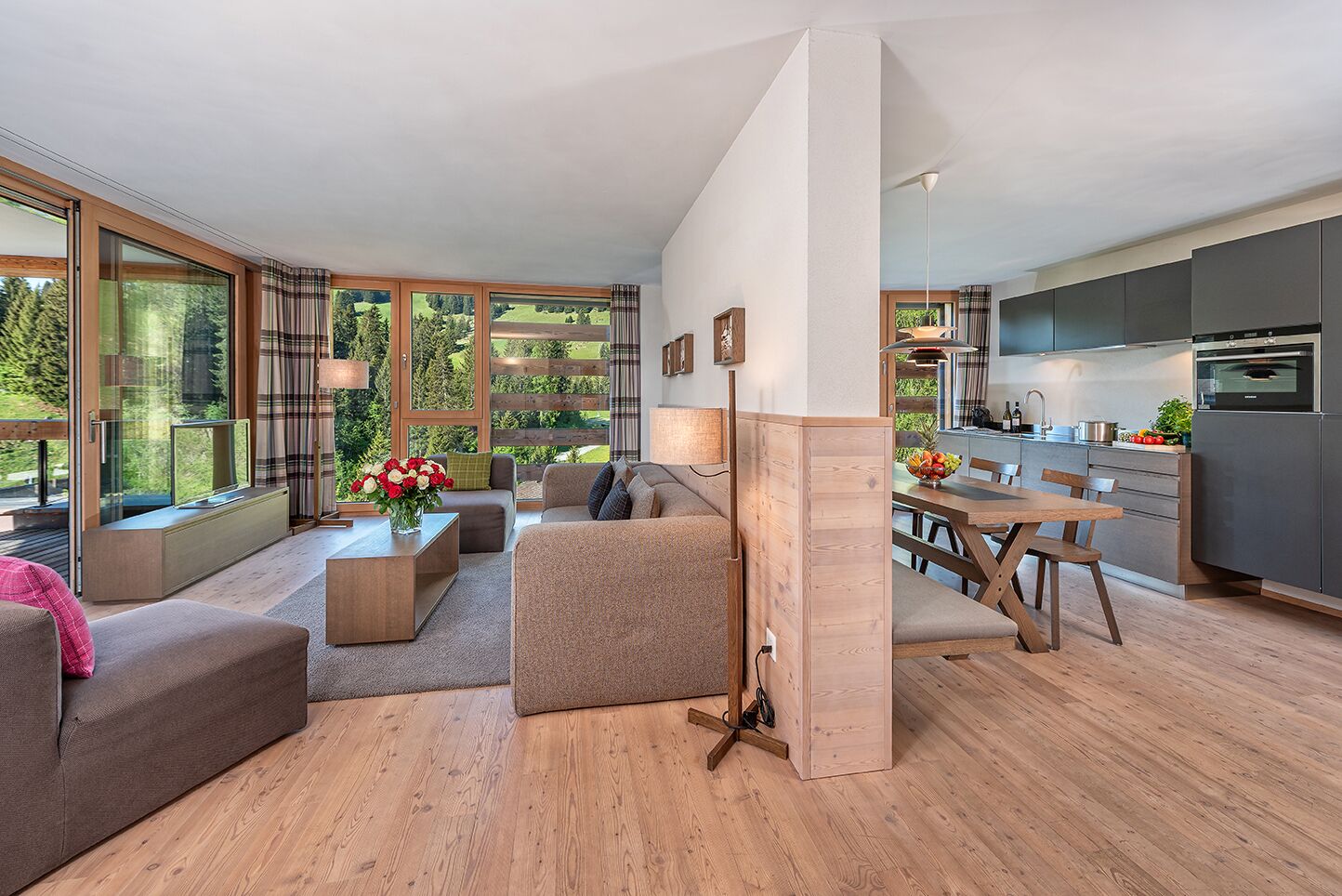 A modern living room with a sofa, coffee table, and a dining area with a table and chairs.