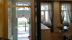 Ett hotellrum med en matplats, utsikt över gatan och en dörr som leder ut.