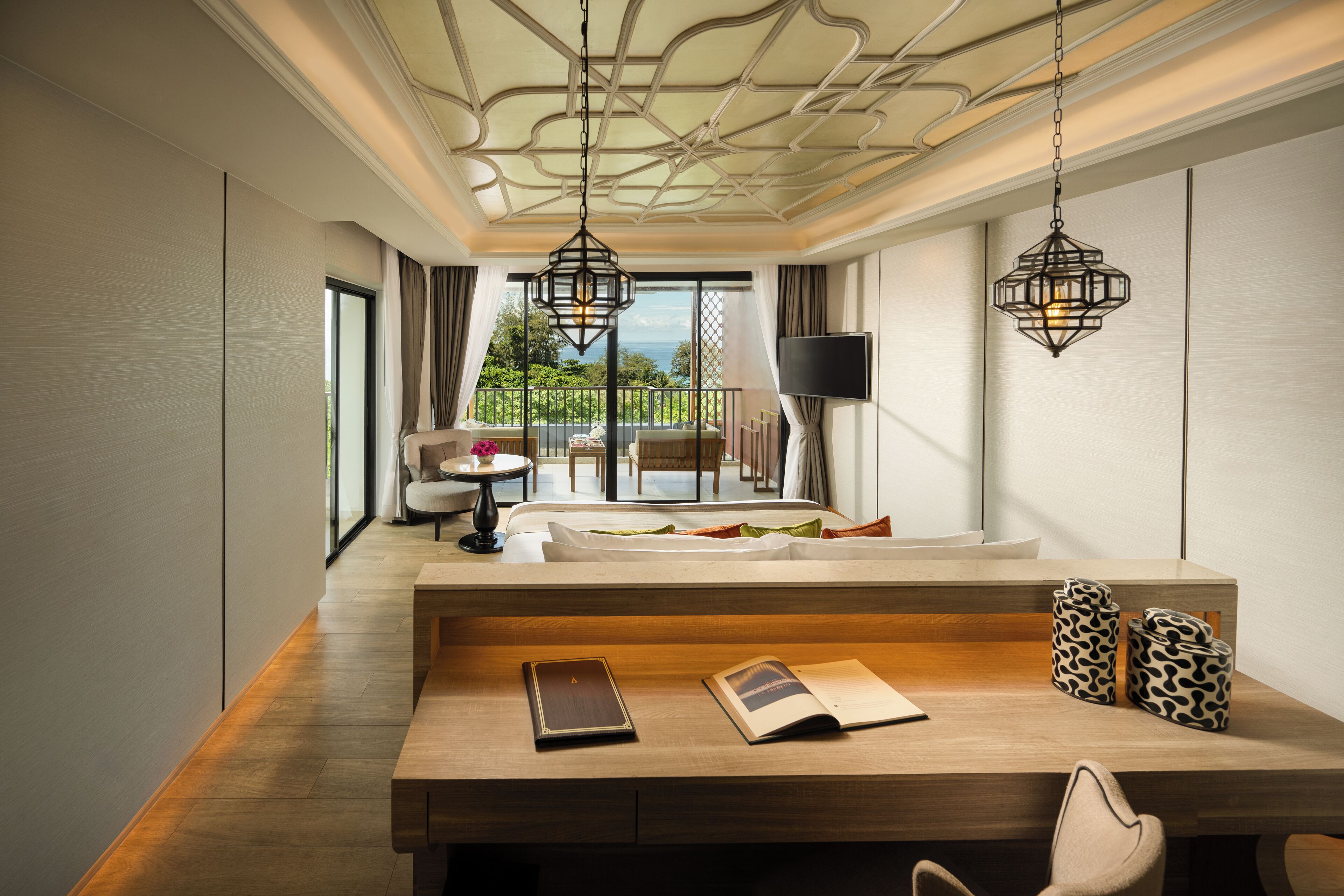 Una habitación de hotel moderna con un escritorio de madera, un sofá y un balcón con vistas.