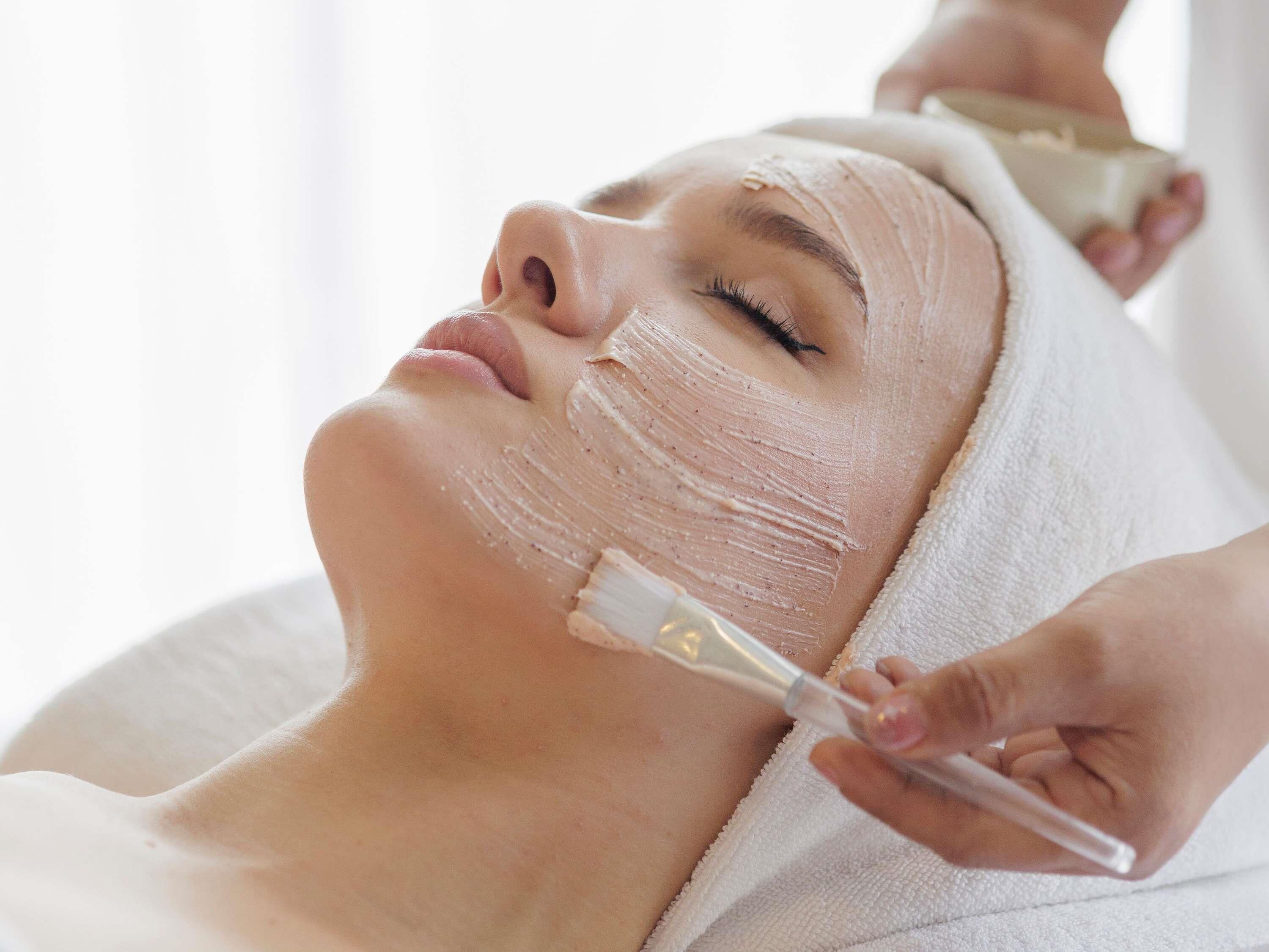 A person receiving a facial treatment with a facial mask.
