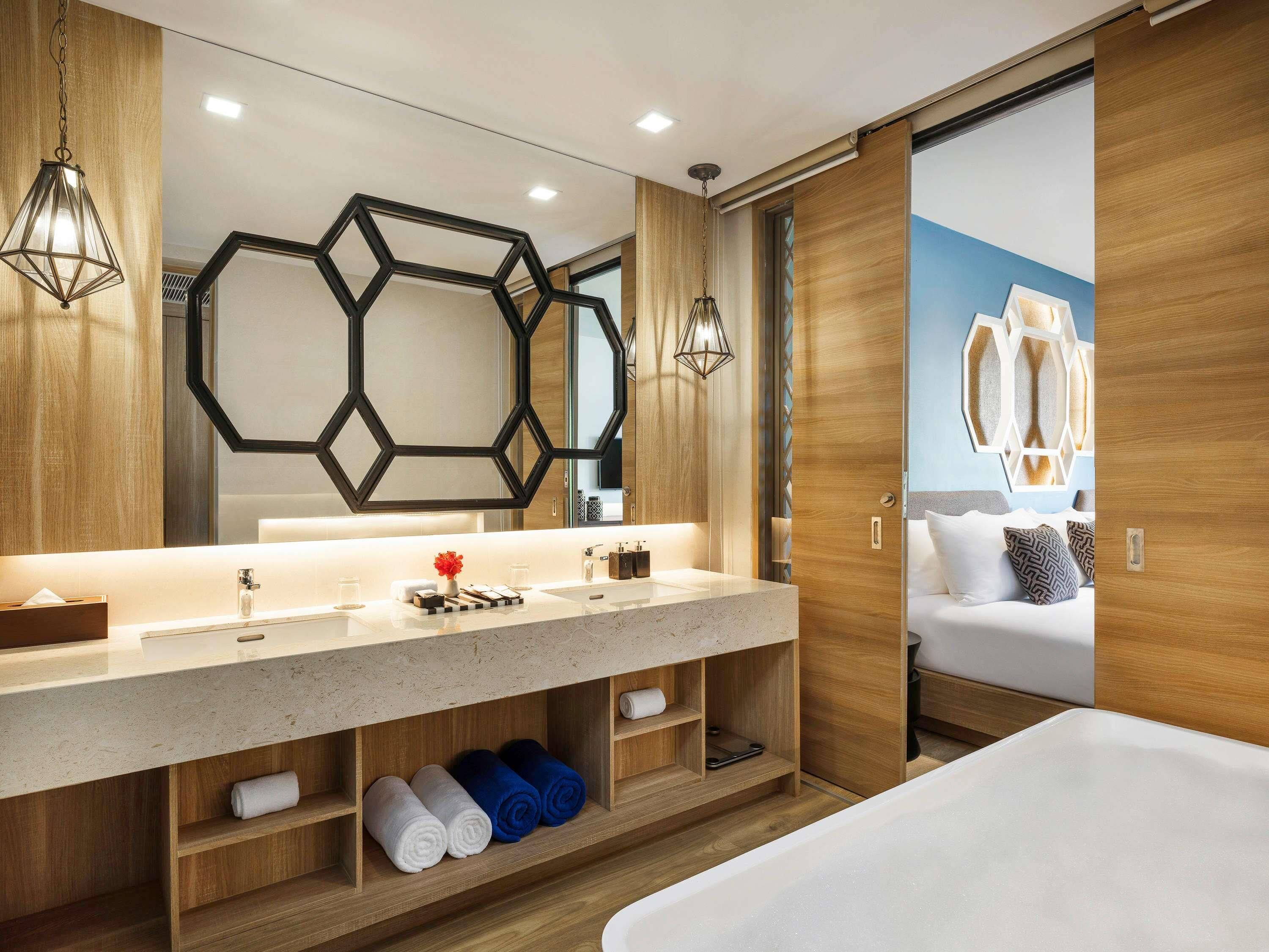 A modern bathroom with a large mirror, wooden paneling, and a built-in shower area.