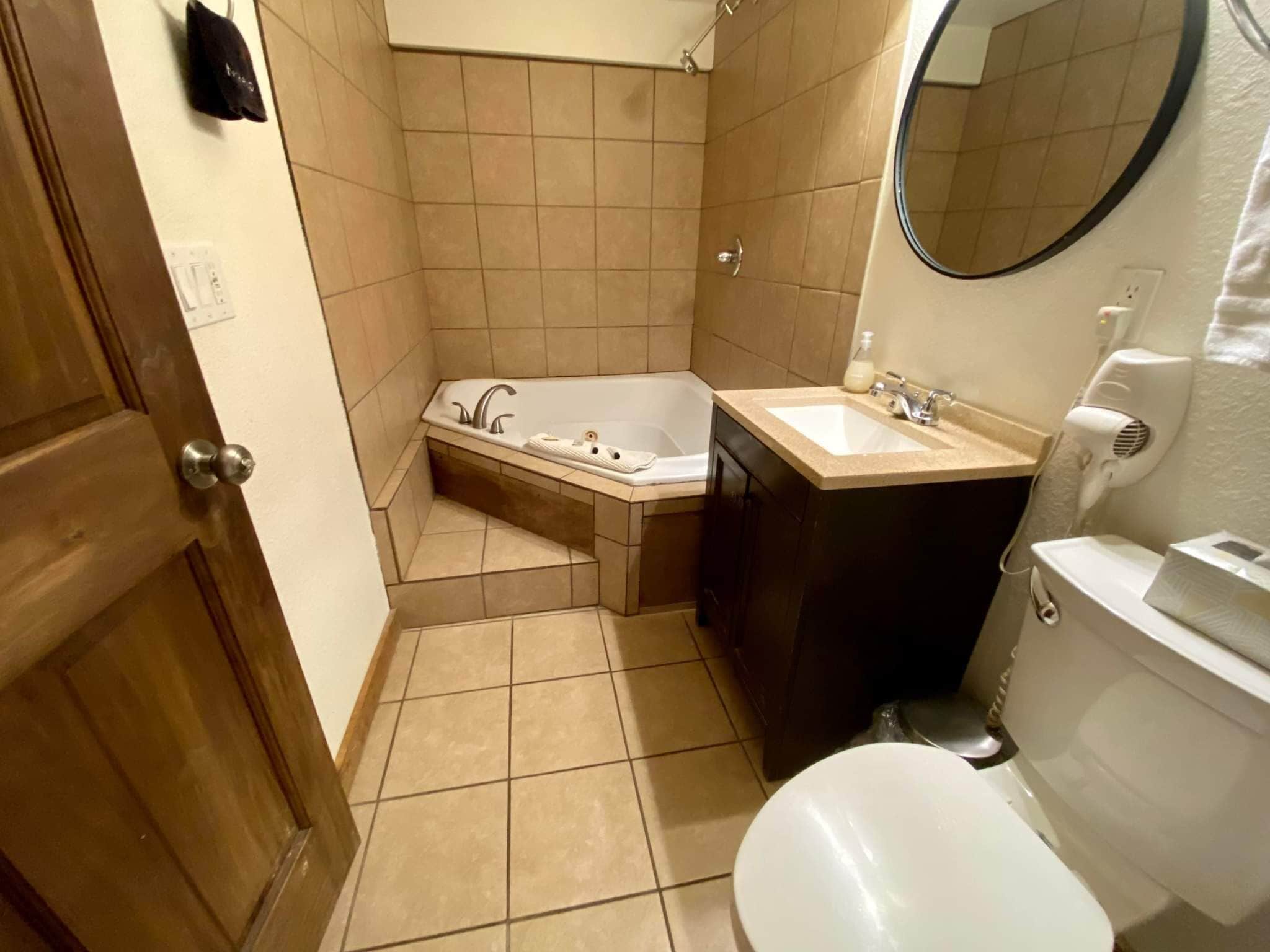Ein Badezimmer mit Badewanne, Waschbecken, Toilette und Spiegel.