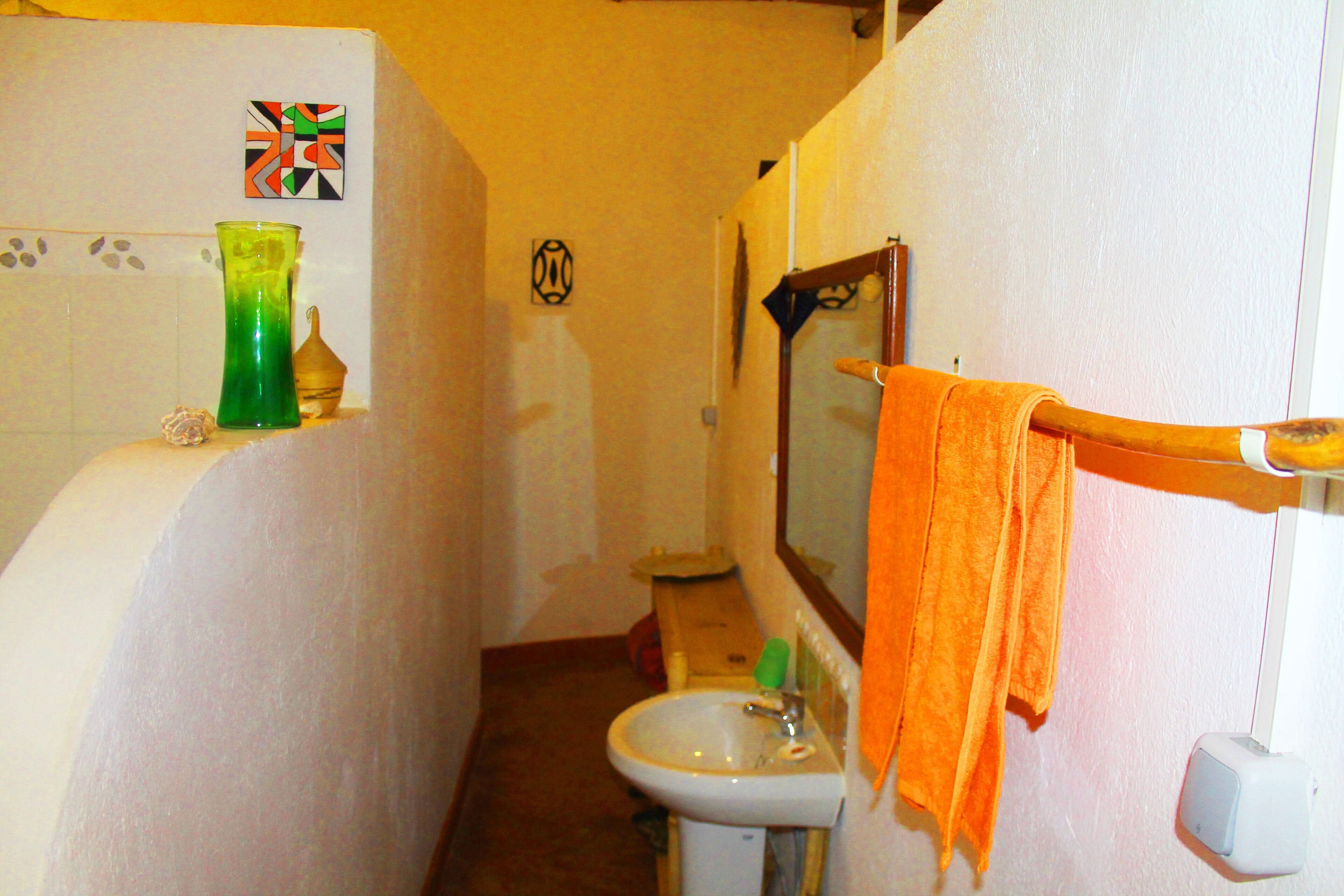 A narrow bathroom with a bathtub, a sink, and a mirror.