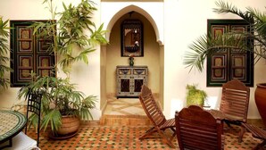 Un intérieur marocain traditionnel, avec un sol carrelé, des meubles en bois et des éléments décoratifs.