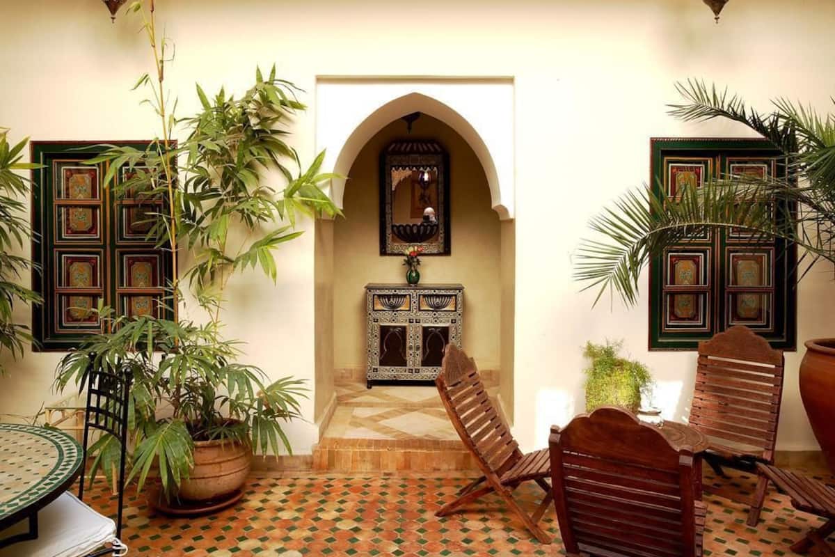 A traditional Moroccan interior with a tiled floor, wooden furniture, and decorative elements.