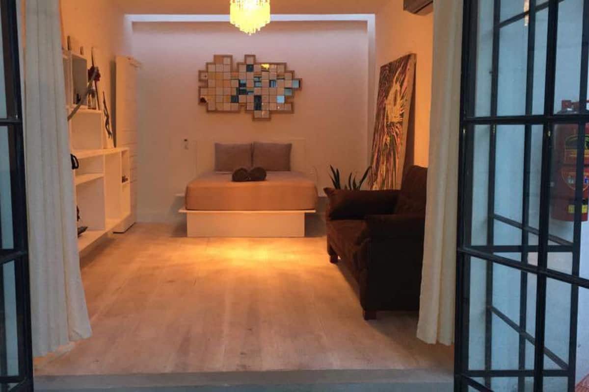 Un dormitorio con una cama, una obra de arte en la pared y una silla.