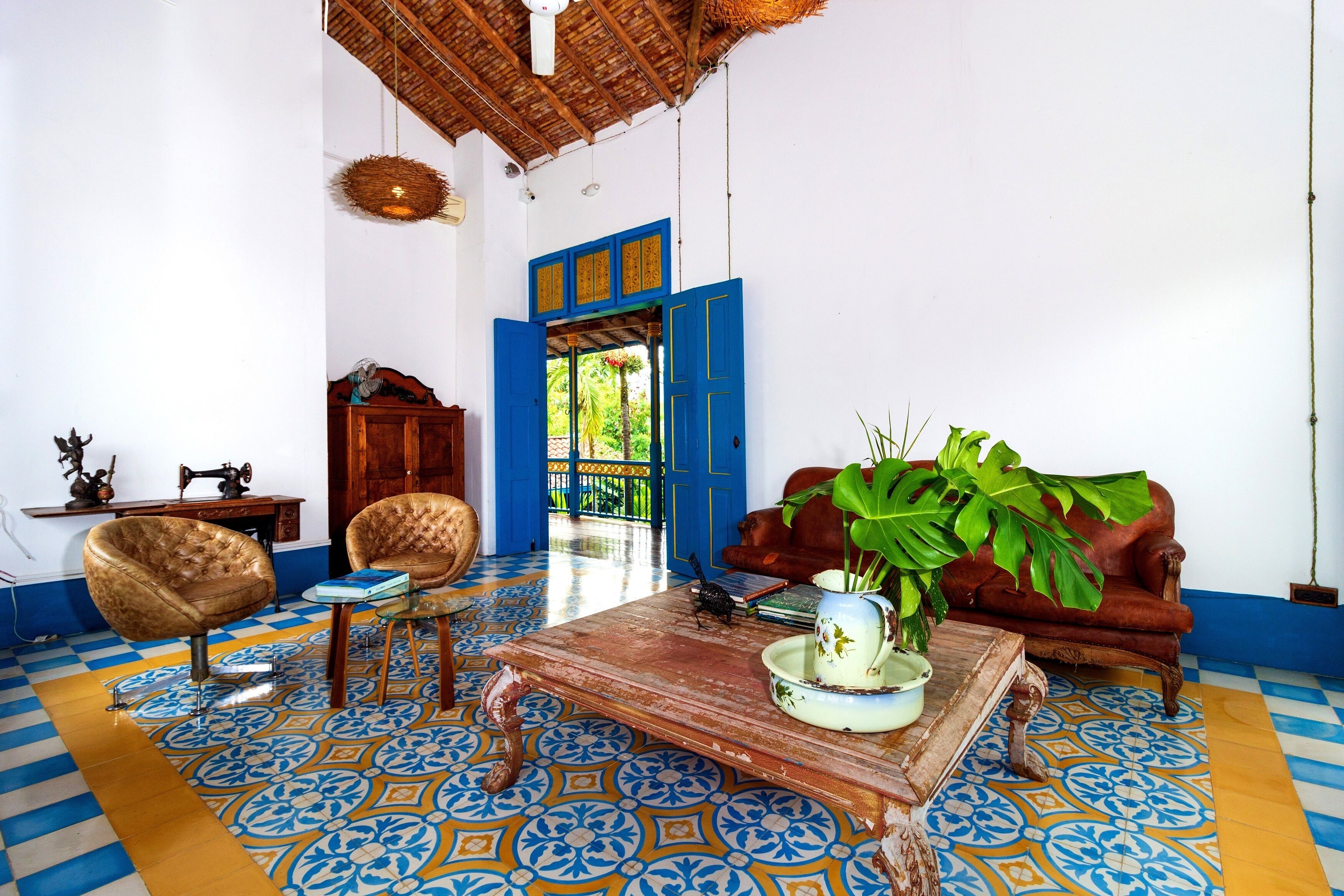 A room with a patterned floor, a wooden coffee table, a sofa, and a chair.