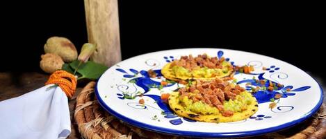 Un plato con dos porciones de comida sobre un plato decorativo, colocado sobre un tapete tejido.