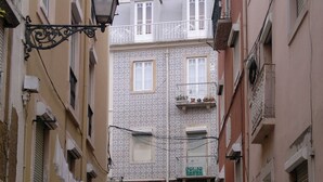 A narrow cobblestone street flanked by buildings with patterned facades and wooden doors. - In the heart of the Portuguese capital (Lisboa)