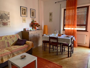 Un salon confortable avec un canapé, une table à manger et un coin cuisine.