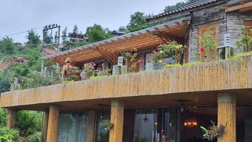 Un bâtiment rustique en bois, doté d’un balcon orné de fleurs et de plantes.