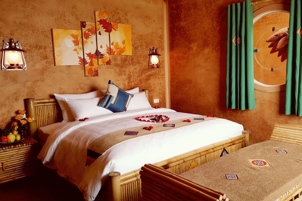 Une chambre d’hôtel bien rangée, avec un lit, une table de chevet et une petite table sur laquelle est posé un set de table.