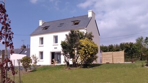 A two-story house with a sloped roof, a front door, and a small porch. - Cottage on the Crozon peninsula (Lanvéoc)