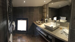 Un baño moderno con un espejo grande, un lavabo blanco y un perchero para toallas.