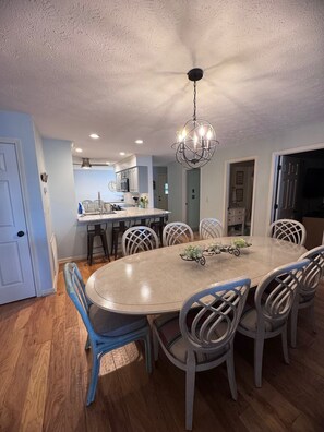 A dining area with a round table, chairs, and a chandelier. - Incredible View Waterfront Condo, Great Location-Boat Rental-Pool-Fire Pit (Benton)