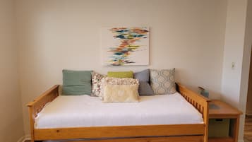 Cozy retreat with a wooden bed, nightstand, and vibrant artwork.