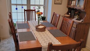 A dining room with a wooden table, chairs, a chandelier, and a view through a window. - Shenandoah Paradise – Best River & Mountain Views in Harpers Ferry
 (Harpers Ferry)