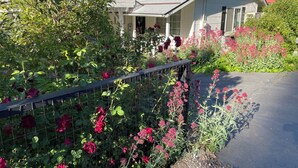 A house with a garden full of flowers and a metal fence. - DOWNTOWN MURPHYS, HALF BLOCK TO MAIN ST (Murphys)