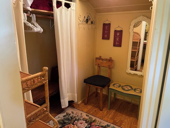 A small, cozy bathroom with a wooden chair, a bench, a mirror, and a shelf with towels. - DOWNTOWN MURPHYS, HALF BLOCK TO MAIN ST (Murphys)