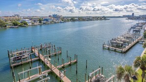 Un puerto deportivo con muelles y barcos, rodeado de edificios residenciales y un cielo despejado.