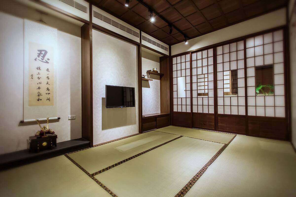 A traditional Japanese room with tatami flooring, a television, and a shoji screen.