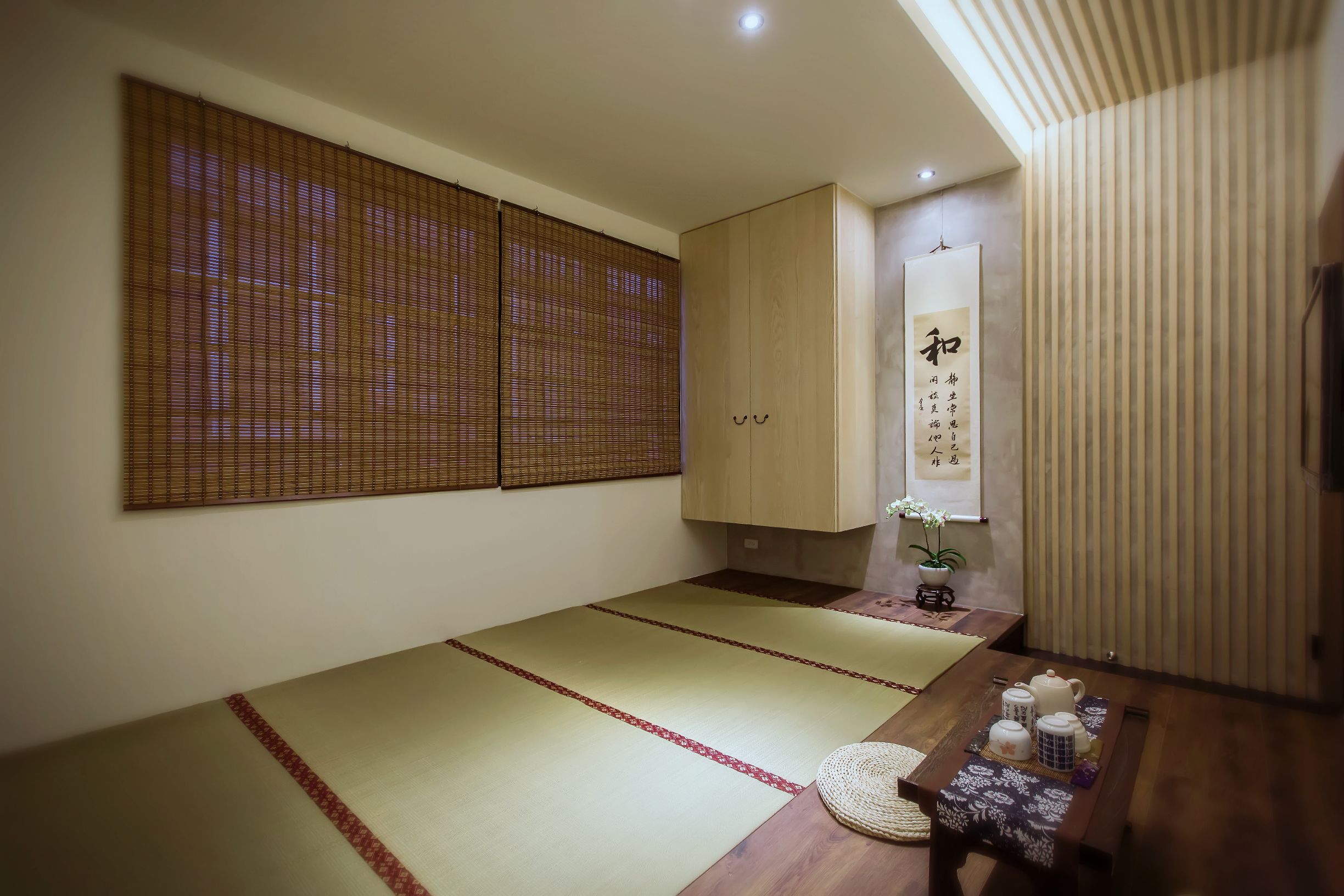 A traditional Japanese room with tatami mats, a wooden table with tea set, and sliding doors.