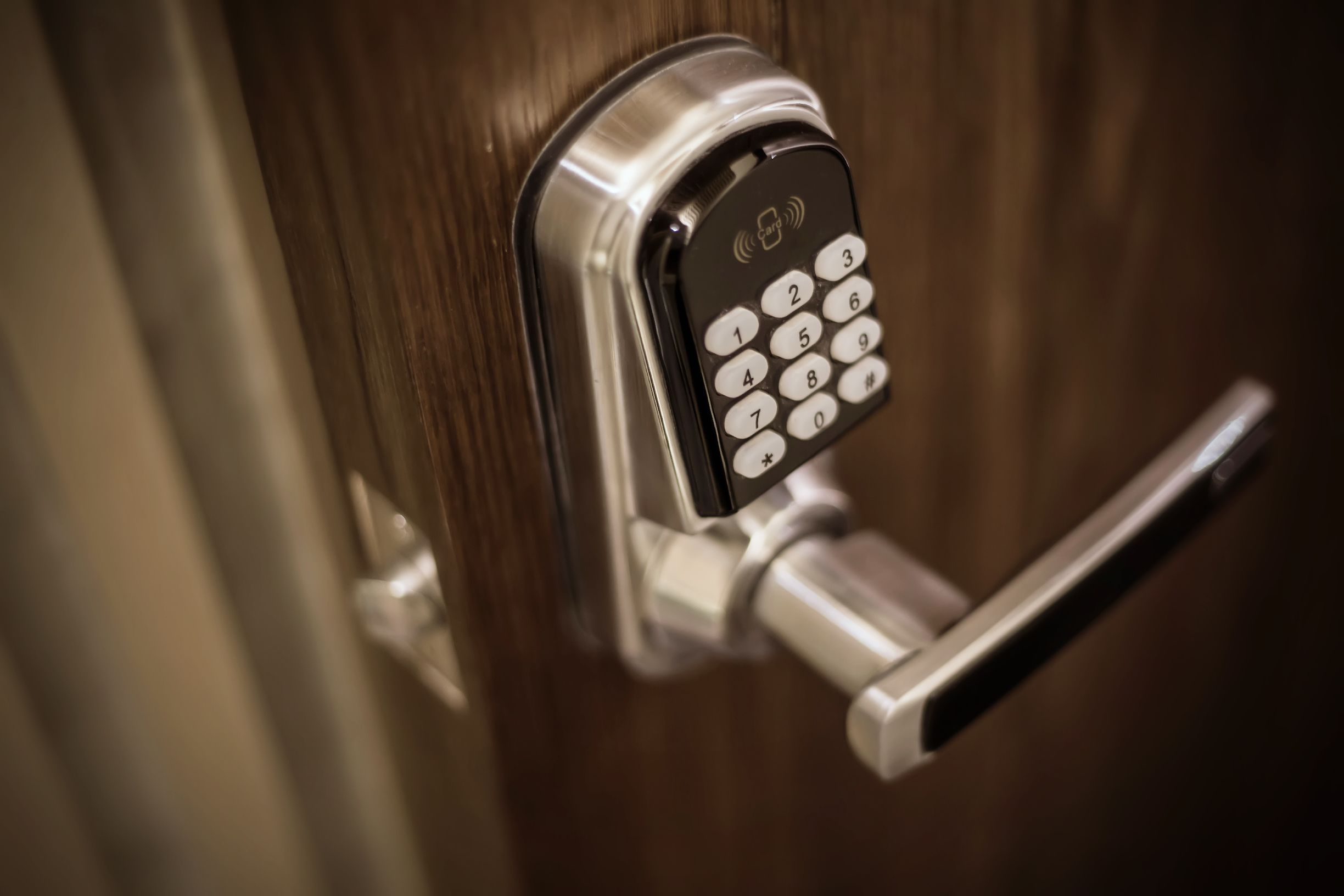 A modern door lock with a keypad, a metallic handle, and a keyhole.