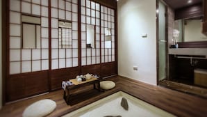 Um quarto tradicional japonês com tatames, um painel shoji e uma pequena mesa com serviço de chá.