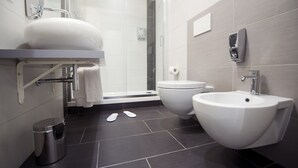A modern bathroom with a large sink, bidet, and separate toilet. - Grey&White B&B (Rome)