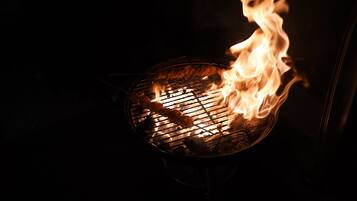 A grill with visible flames and food being cooked.