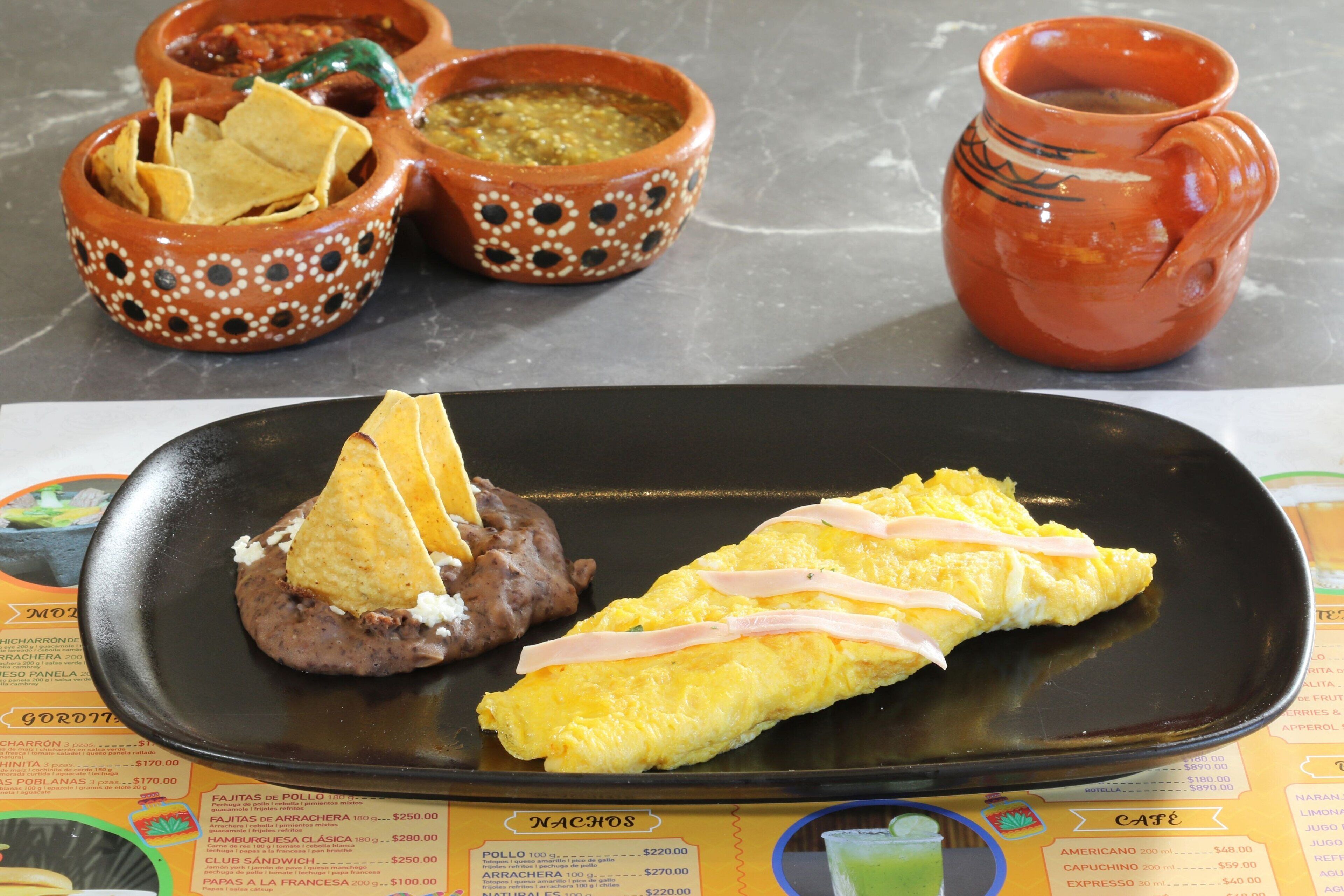 Un plato con nachos, frijoles y una tortilla.