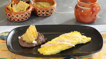 Un plato con nachos, frijoles y una tortilla.