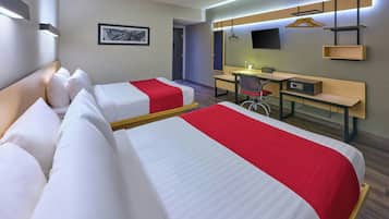 Een hotelkamer met twee bedden, een bureau, een stoel, een televisie en een wandplank.