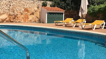 Et oppvarmet basseng og solsenger