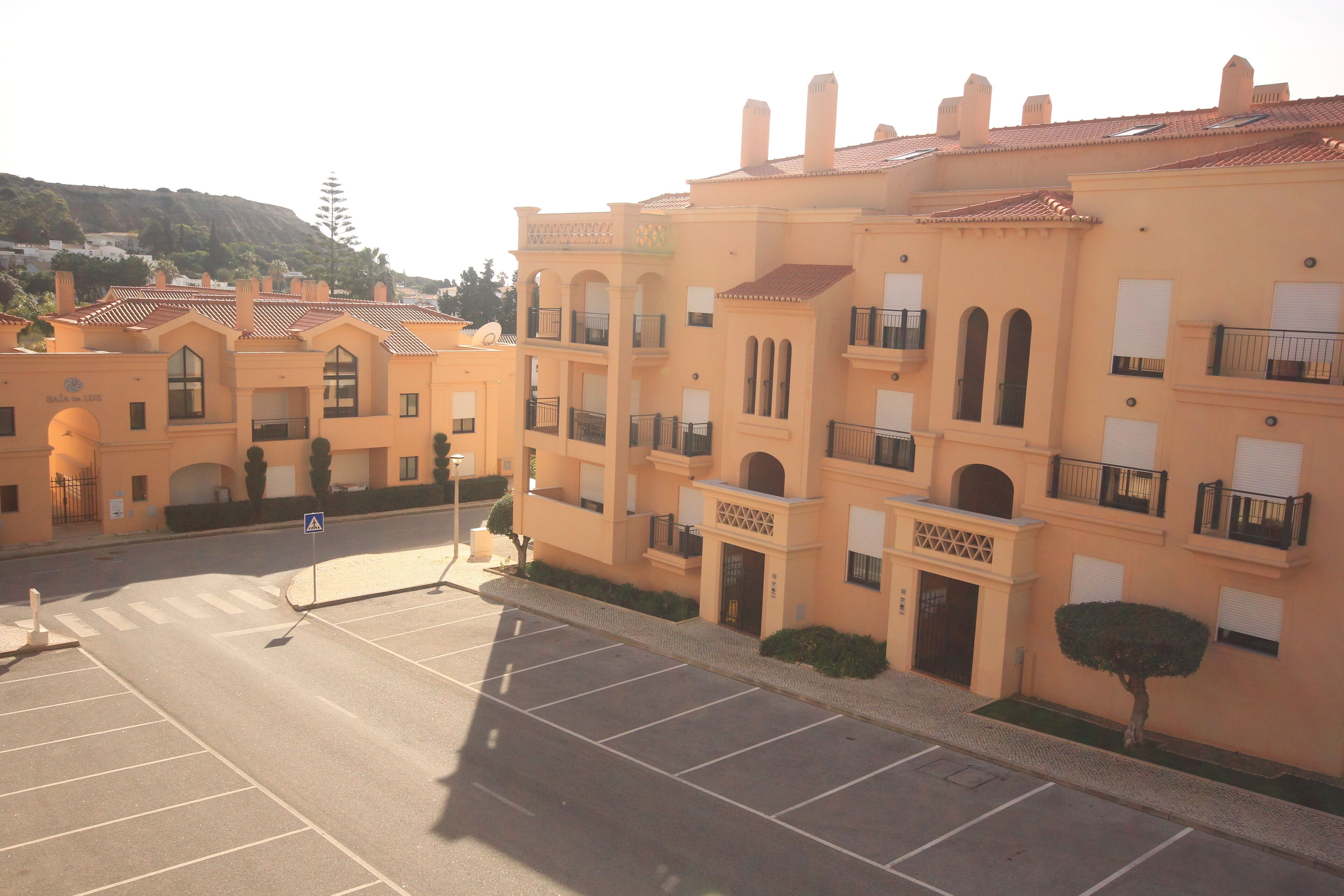 A multi-story building with a uniform architectural style, featuring balconies and a central entrance.