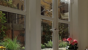 A kitchen with a gas stove, a sink, and a window with a view of greenery and flowers. - terrace viadelloca35  (Roma)