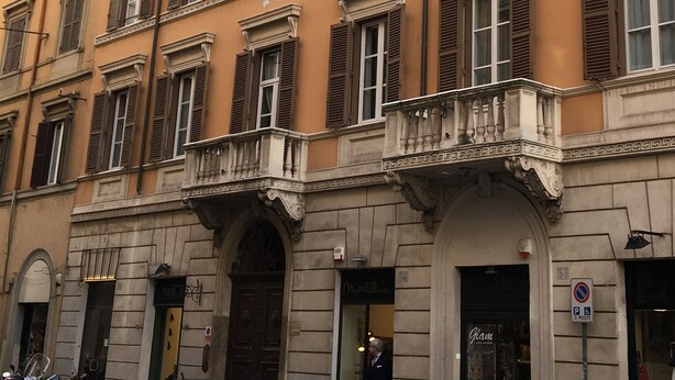 A multi-story building with a classic architectural style, featuring symmetrical windows with shutters, ornate balconies, and a ground-level entrance with a sign. - terrace viadelloca35  (Roma)