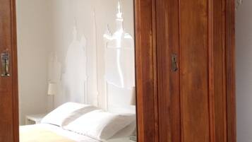 A wooden wardrobe with a large mirror.