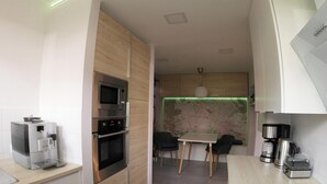 Una cocina moderna con electrodomésticos integrados, un comedor con un mapa en la pared y una cafetera.