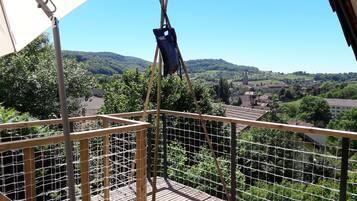 Un punto de vista elevado con vistas a un pueblo, un puente colgante y una estructura con mosquitero.