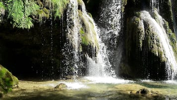 Een waterval die over mosbedekte rotsen stroomt.