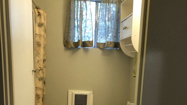 A small bathroom with a toilet, sink, and shower. - Cozy Creekside Cottage (Cascade)