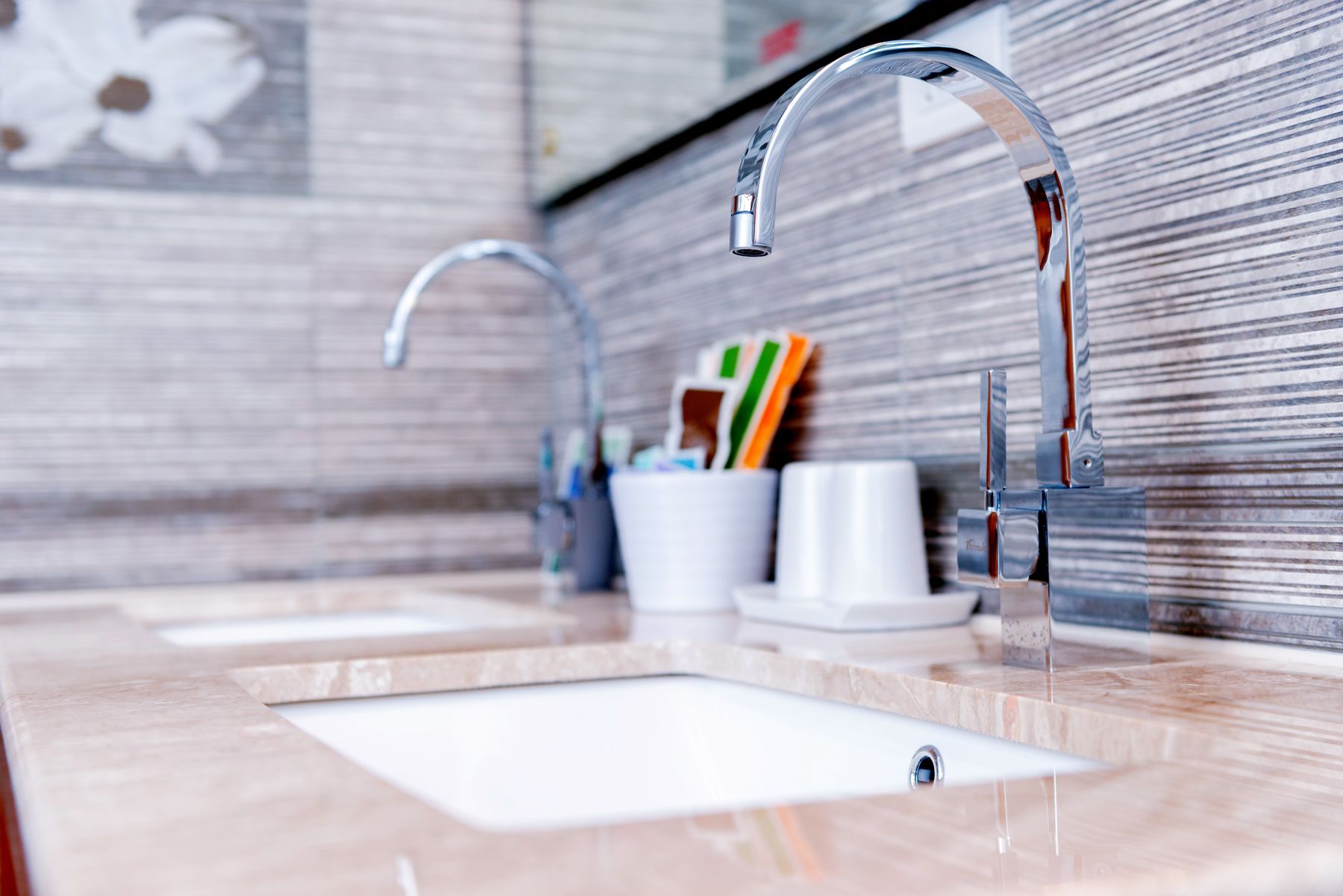 A bathroom with two sinks, a mirror, and a towel rack.